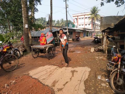 বন্যায় খতিগ্রস্থ রাস্তা মেরামত করছেন ব্যবসায়ী গোলক মন্ডল